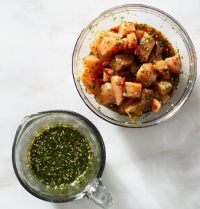 Chicken and marinade in glass bowls.