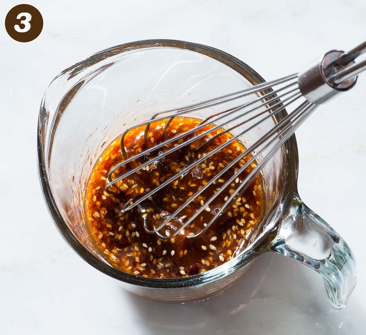 Ginger sesame sauce being whisked in a cup.