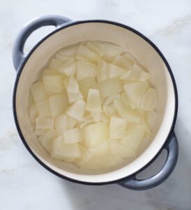 Cooked onion chunks in a pot.