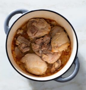 Seared chicken thighs in a Dutch oven.