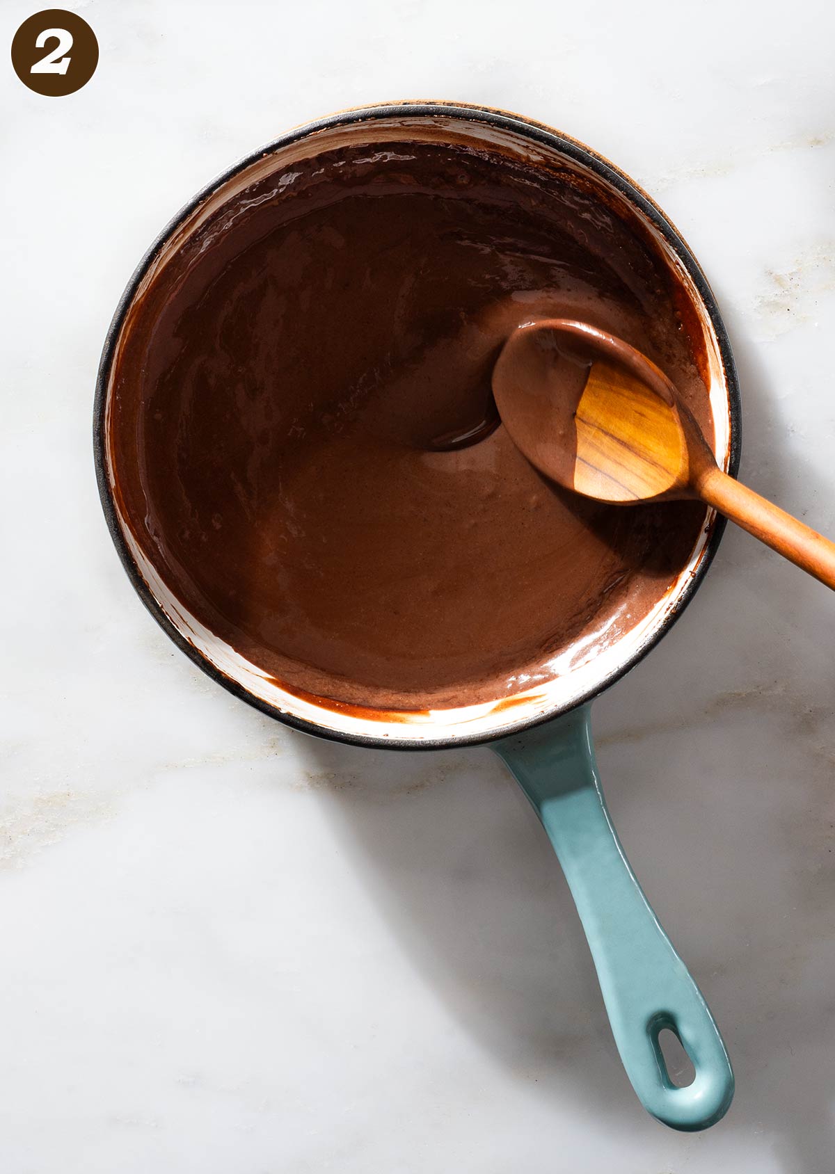 Chocolate mix being stirred in a saucepan.