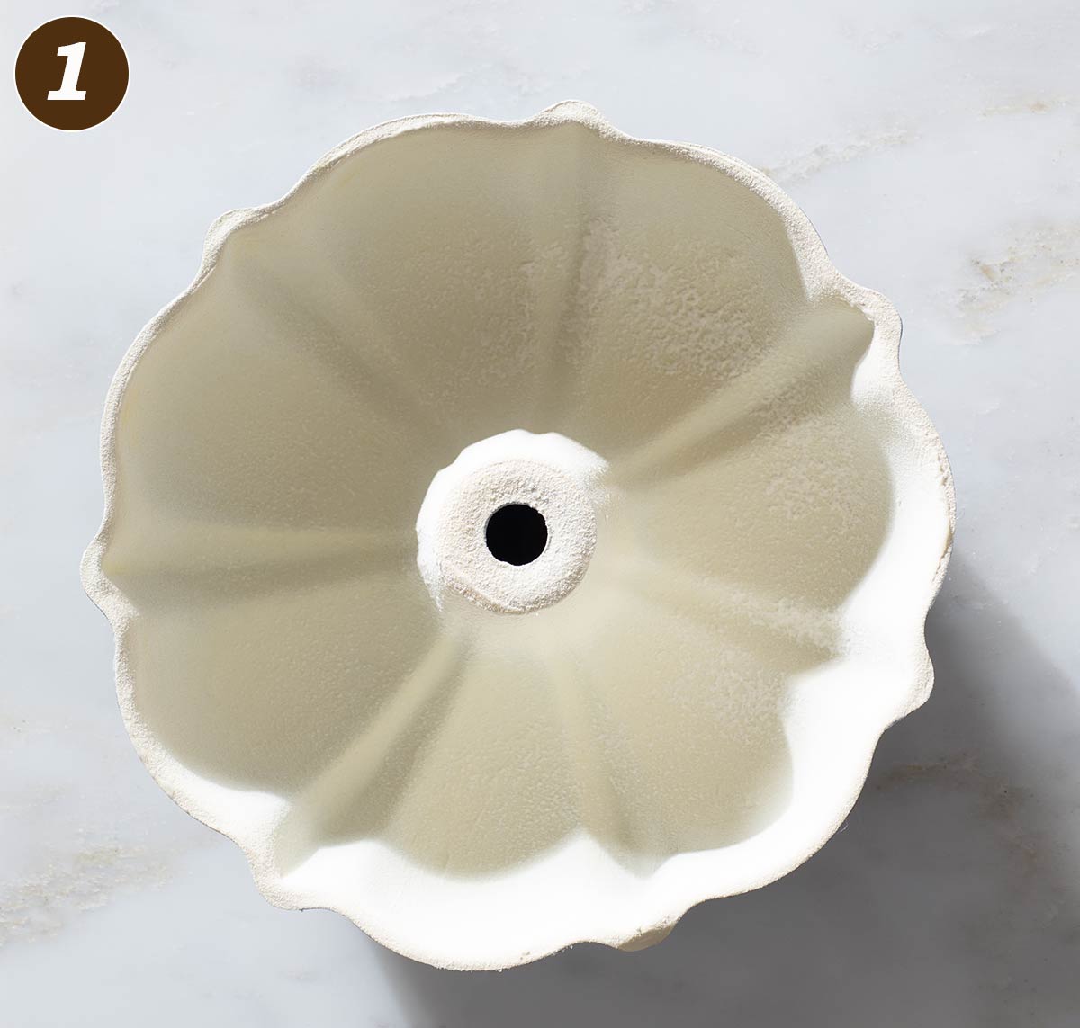 Greased bundt cake pan on a table.