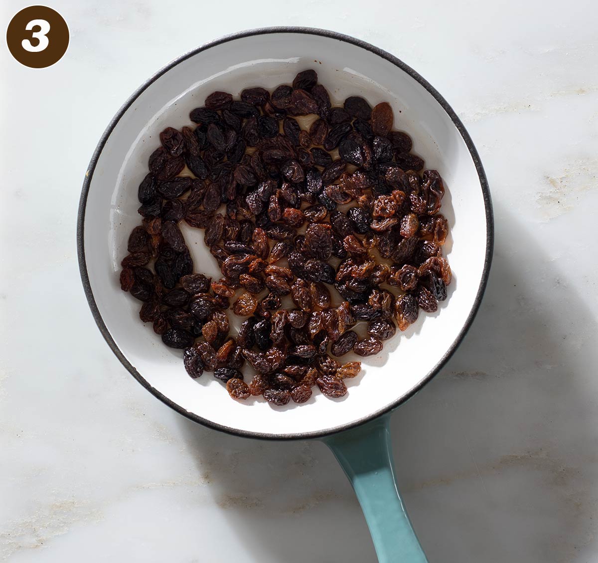 Rum-soaked raisins in a saucepan.