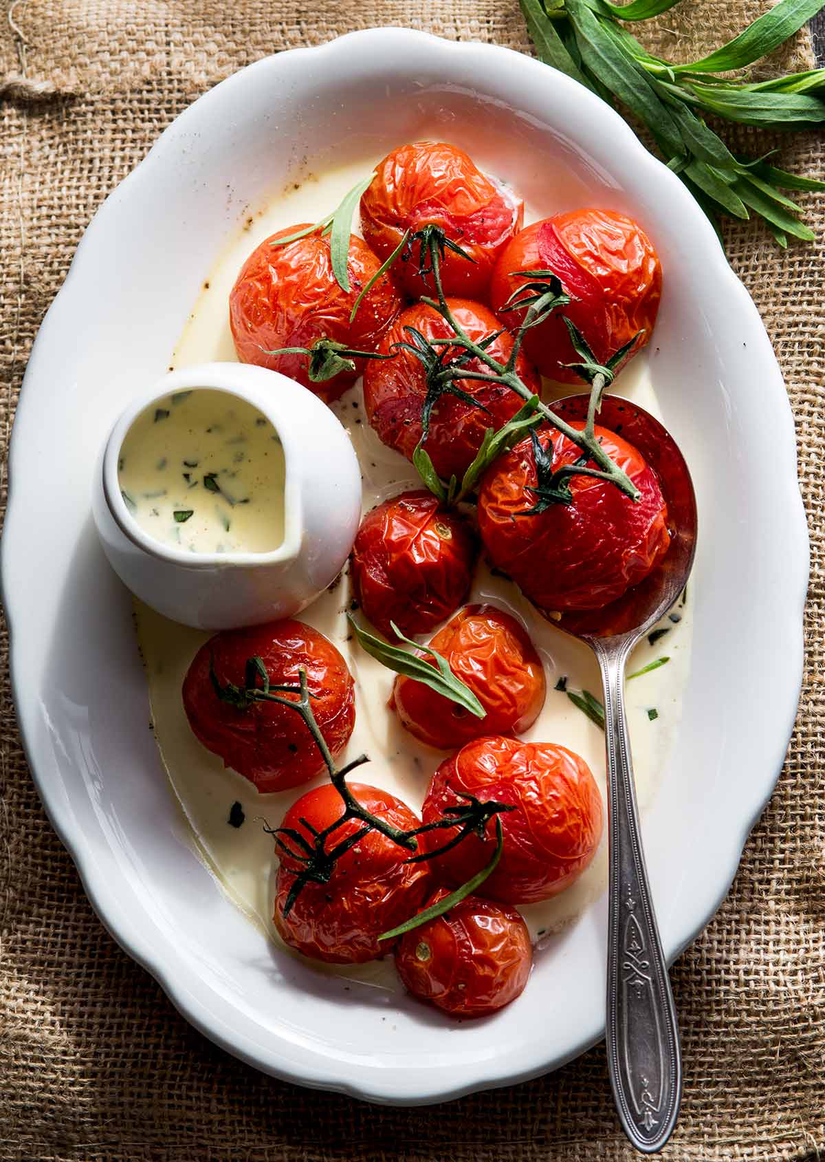 Tarragon cream sauce with roasted tomatoes on a plate.