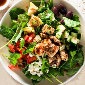 Mediterranean grilled chicken salad with sumac dressing on a plate.