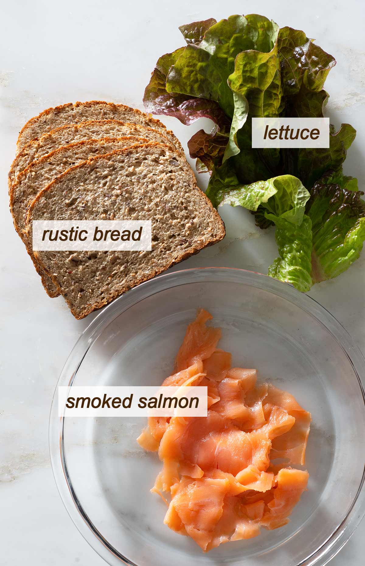 Smoked salmon panini sandwich ingredients on a table.