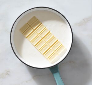 Cream and a white chocolate bar in a saucepan.