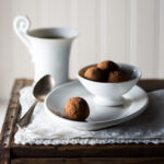 Chocolate ginger truffles and a cup on a table.