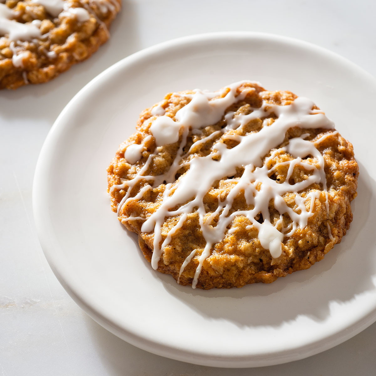 A large glazed Holiday oatmeal cookie on a plate.