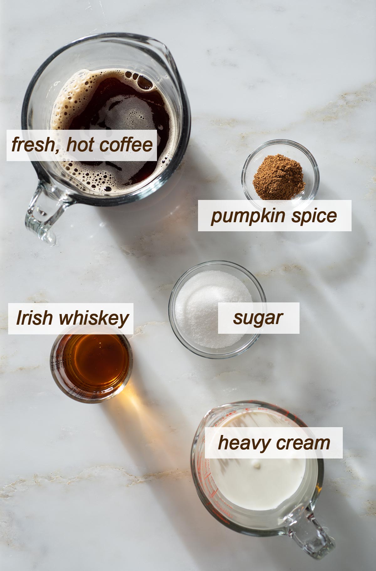 Pumpkin spice Irish coffee ingredients on a table.