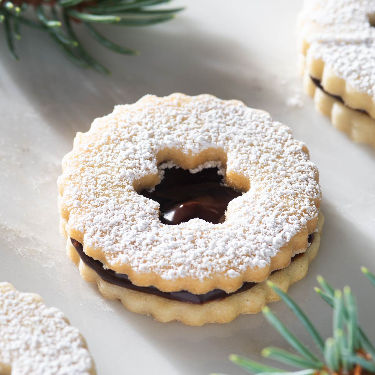 Closeup of a Linzer cookie filled with chocolate ganache.