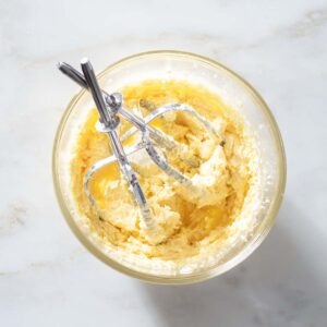 Whipped frangipane in a bowl with beaters.
