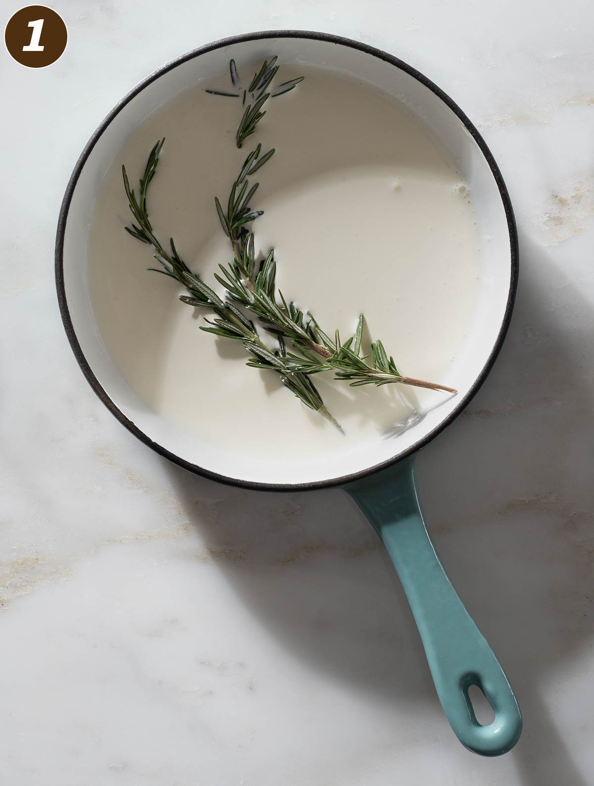 Rosemary and cream in a saucepan.