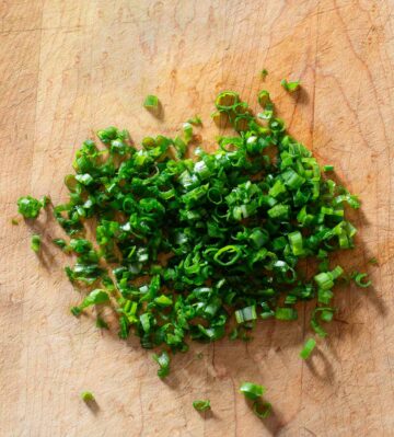 Chopped scallion greens on a cutting board.