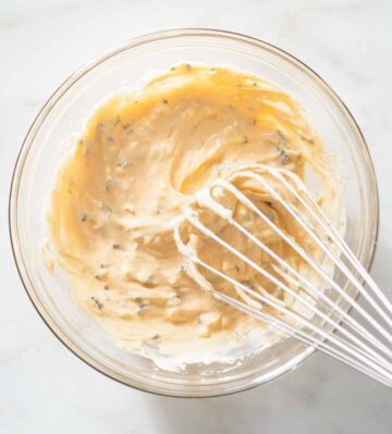 Scallion aioli being whisked in a bowl.