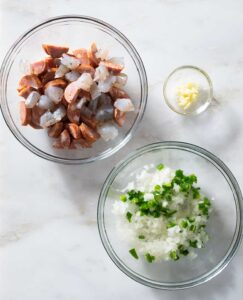 Prepared meat and vegetables in bowls.