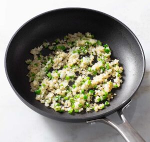 Sauteed onion and jalapeno pepper in a pan.