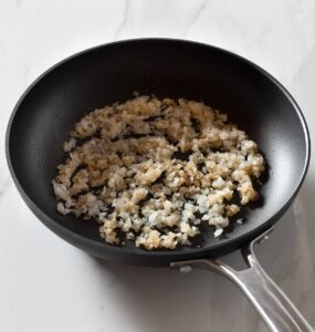 Sauteed onion with cumin in a pan.