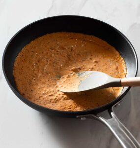 Creamy chipotle sauce being stirred in a pan.
