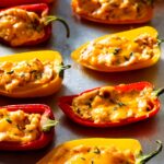 Baked stuffed mini peppers on a baking sheet.