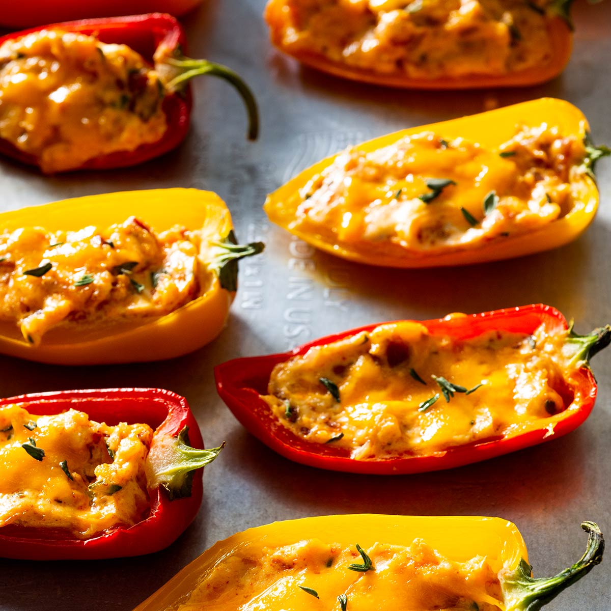 Baked stuffed mini peppers on a baking sheet.