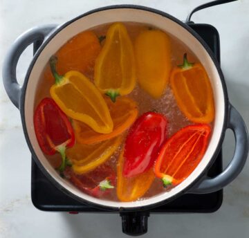Sweet peppers in a pot of boiling water.