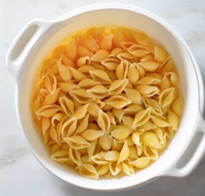 Cooked pasta shells in a colander.
