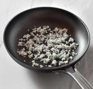 Sauteed diced onion in a pan.