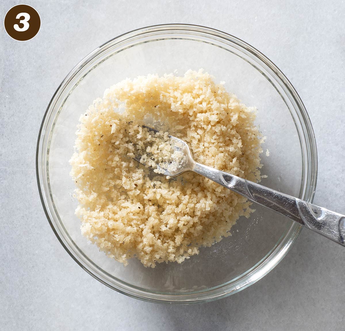 Panko breadcrumbs being mixed in a bowl with a fork.