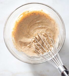 Dressing being whisked in a bowl.