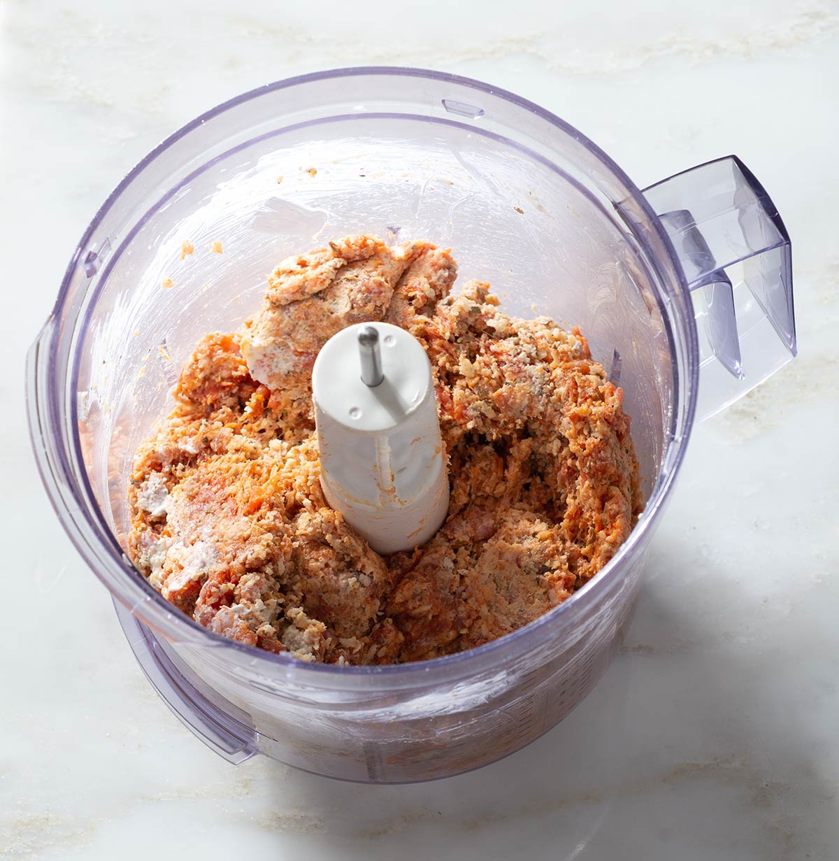 Sausage meatball mixture in a food processor.