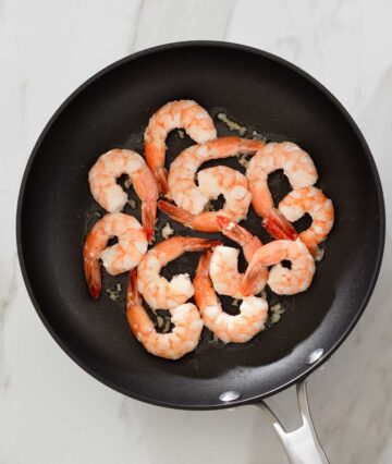 Cooked garlic and shrimp in a pan.