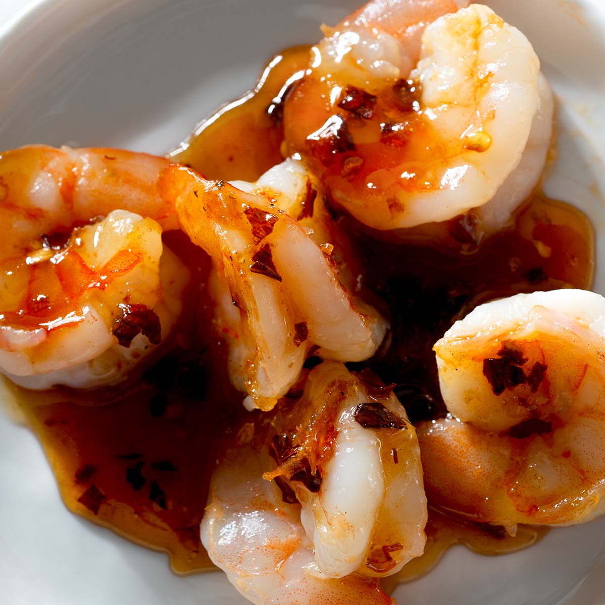 Sweet and spicy shrimp with sauce on a plate.