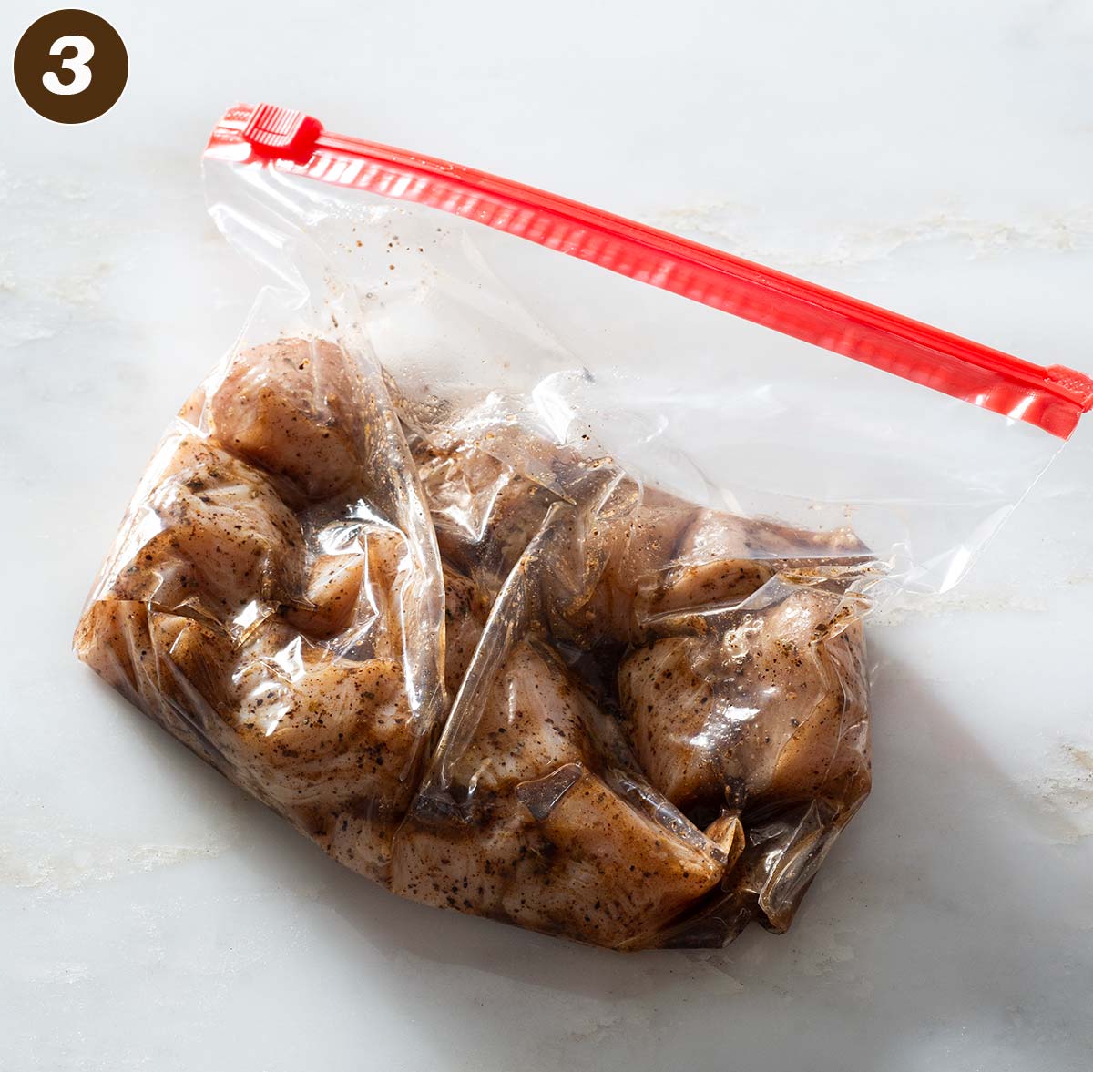 Chicken and marinade in a plastic bag.