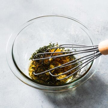 Maple syrup mustard marinade being whisked in a bowl.