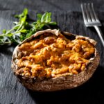 A baked stuffed portobello mushroom on a blue tile.