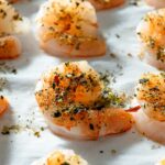 Seasoned shrimp on a baking sheet.