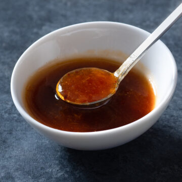 Apricot sauce in a bowl with a spoon.