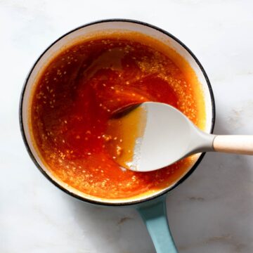 Sriracha sesame sauce being stirred in a saucepan.