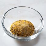 Orange pepper seasoning in a glass bowl.