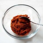 Ancho rub being stirred in a glass bowl.
