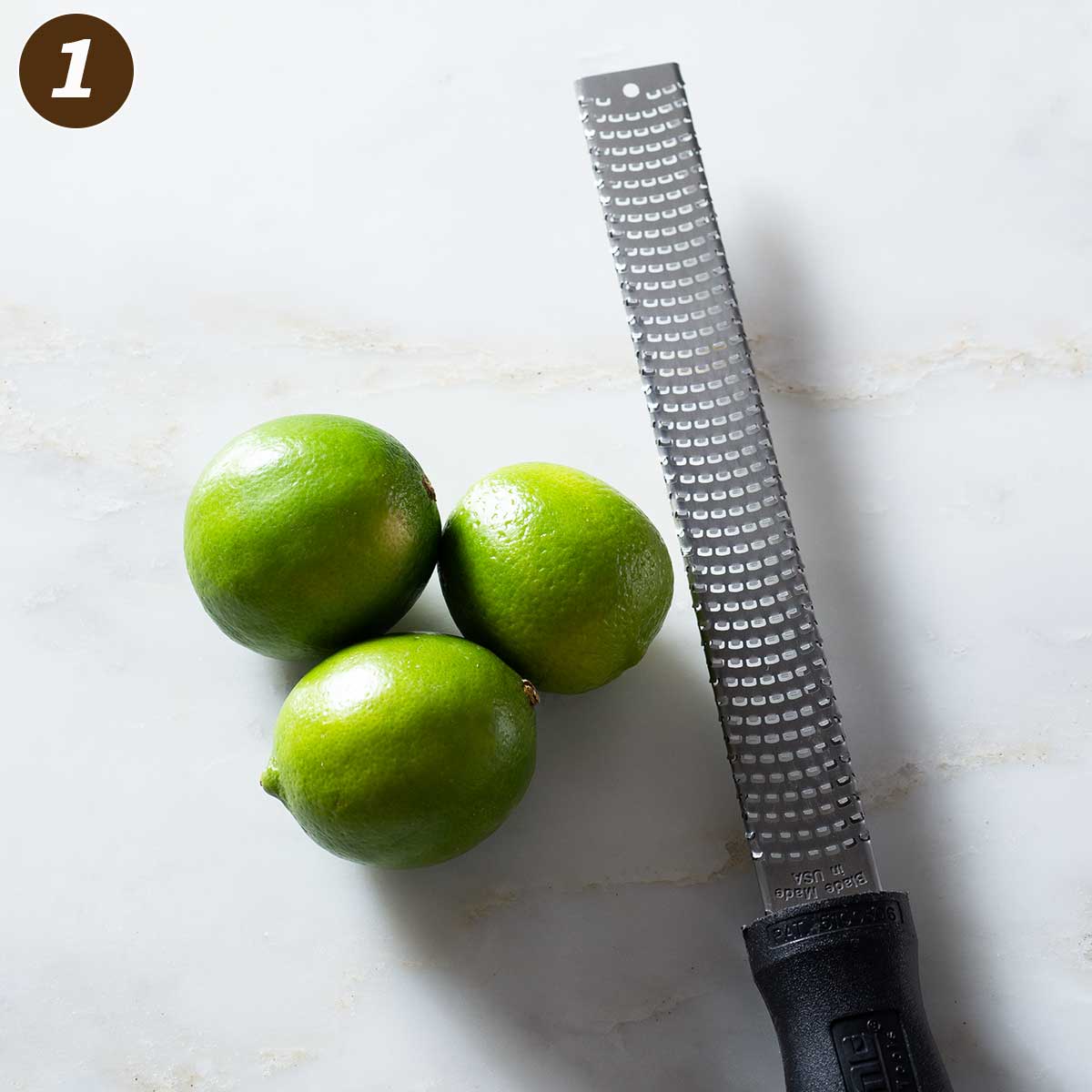 Three limes and a citrus zester.