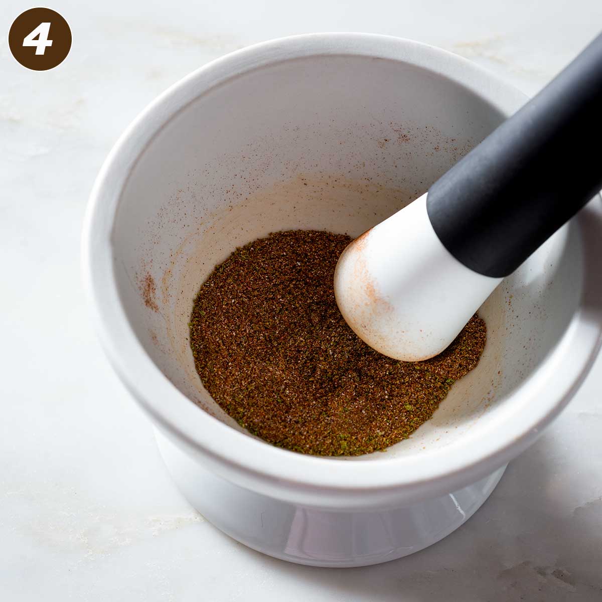 Chipotle seasoning in a mortar with a pestle.