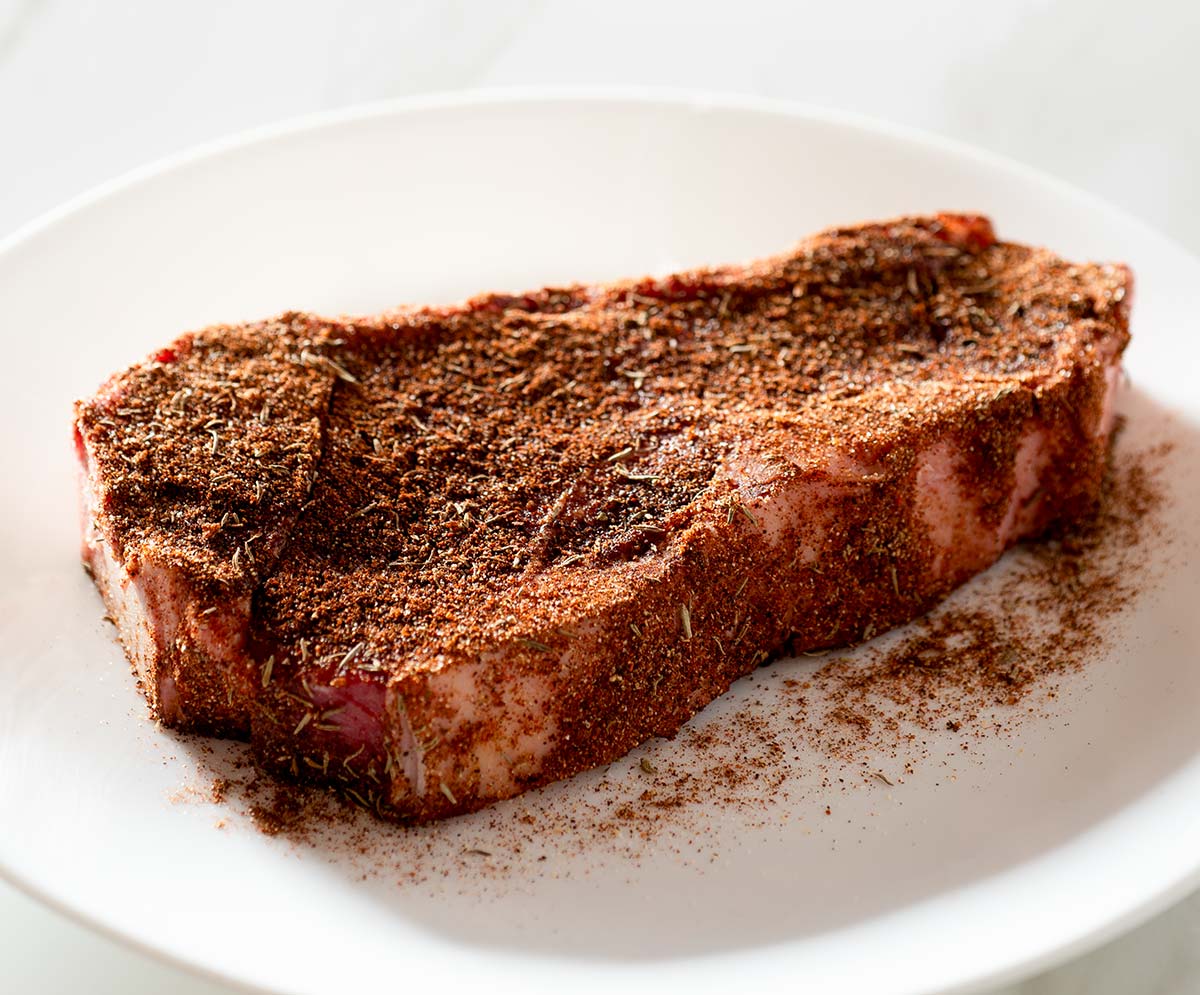 Raw steak with dry rub.
