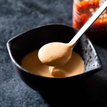 Ginger Sriracha aioli in a bowl with a spoon.