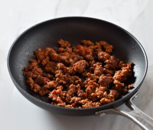 Browned chorizo in a pan.