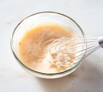 Sweet chili aioli being whisked in a bowl.