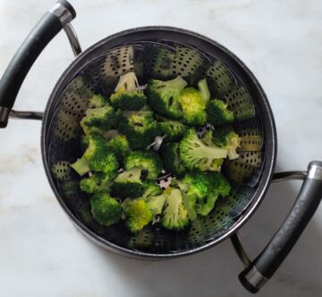 Cooked broccoli florets in a pot.