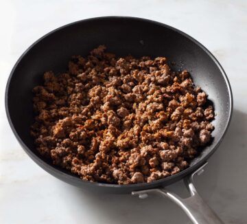 Cooked and seasoned ground beef in a nonstick pan.