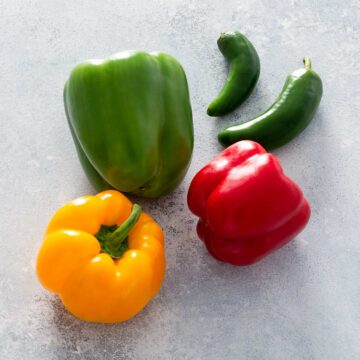 Bell peppers and jalapeno peppers on a table.